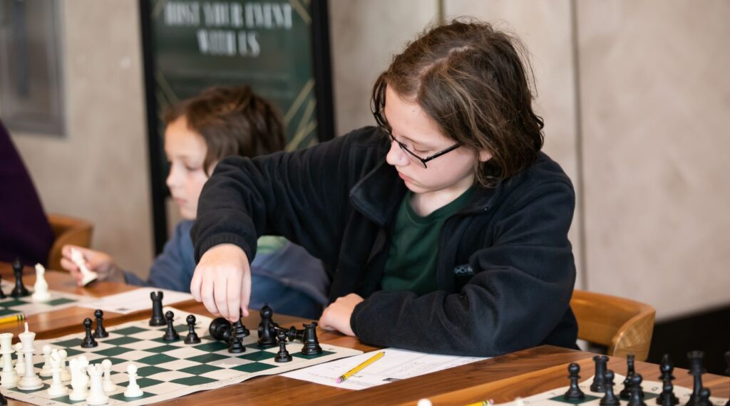 how to improve chess rating fast - young chess student making a move during training session